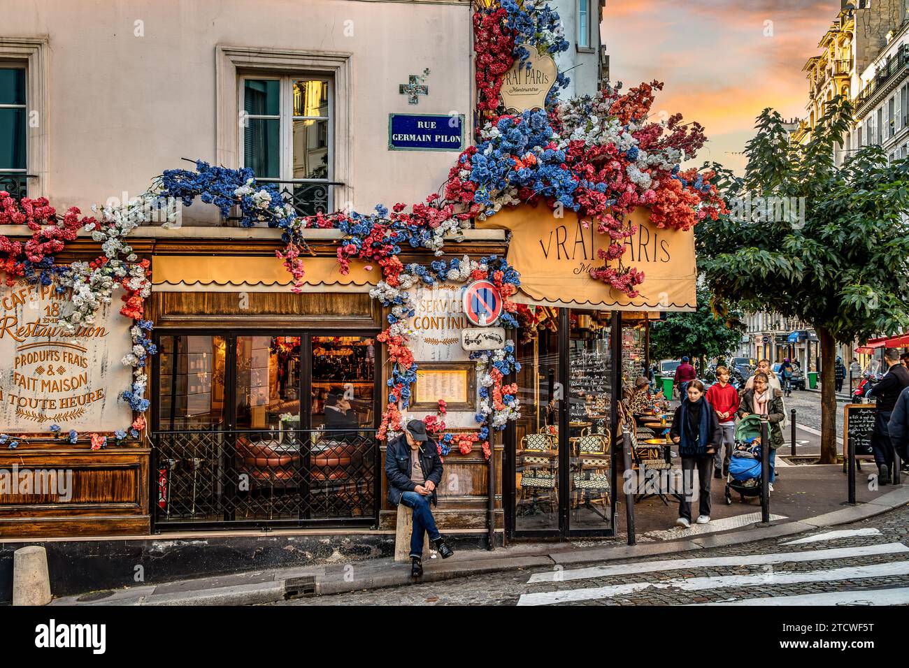 A man standing outside Le Vrai Paris, a lively bisto on Rue Abbesses, Montmartre  in the 18th arrondissement of Paris,France Stock Photo
