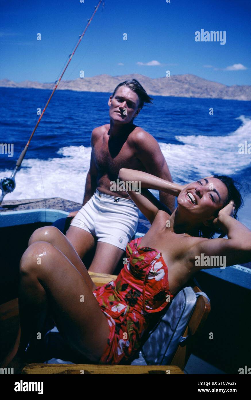 BAJA CALIFORNIA, MEXICO - JUNE, 1962:  Actor and former baseball player Chuck Connors (1921-1992) and actress fiance Kamala Devi (1934-2010) relax on a boat during a fishing trip circa June, 1962 in Baja California, Mexico.  (Photo by Hy Peskin) *** Local Caption *** Chuck Connors;Kamala Devi Stock Photo