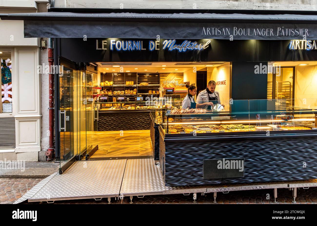 Two people behind the counter at Le Fournil de Mouffetard a Boulangerie Pâtisserie on Rue Mouffetard in the 5th arrondissement of Paris, France Stock Photo