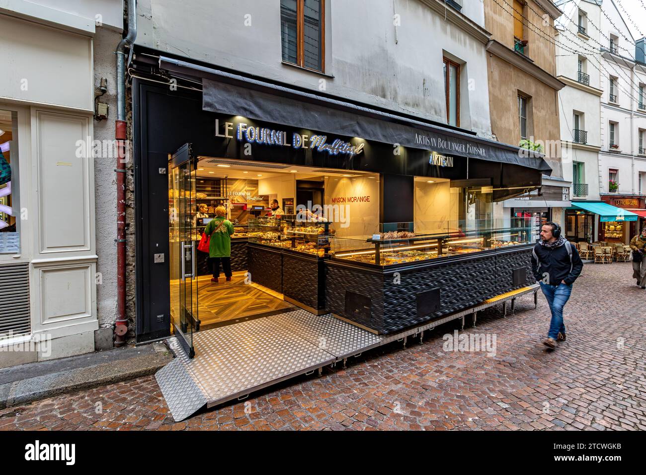 People shopping at Le Fournil de Mouffetard a Boulangerie Pâtisserie on Rue Mouffetard in the 5th arrondissement of Paris, France Stock Photo
