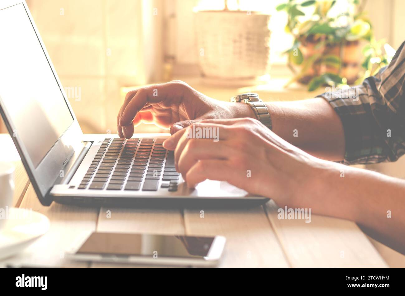 Laptop, phone. Programmer's hands working on laptop keyboard. Stock Photo
