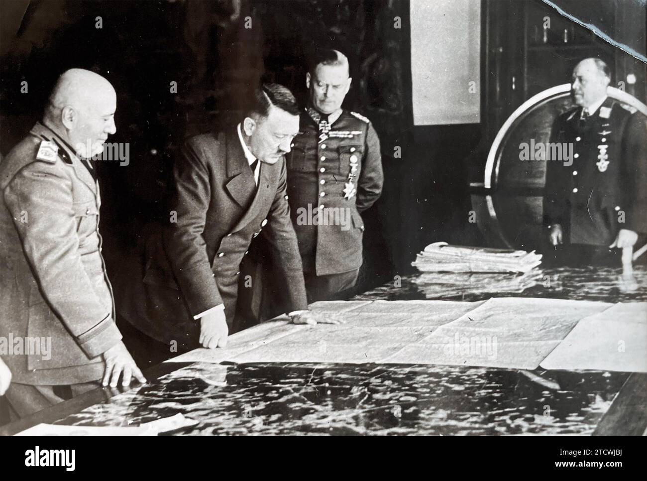 ADOLF HITLER pours over a map in Schloss Klessheim,Salzburg, Austria,  in April1942 watched by Benito Mussolini at left and  General von Rundstedt centre Stock Photo