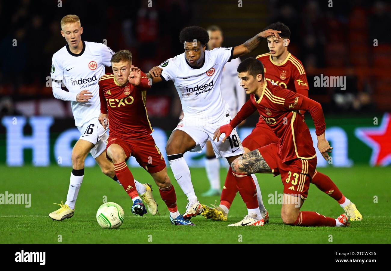 Aberdeen, UK. 14th Dec, 2023. Soccer: UEFA Europa Conference League, FC Aberdeen - Eintracht Frankfurt, Group Stage, Group G, Matchday 6, Pittodrie Stadium. Frankfurt's Jessic Ngankam (center) in action against Aberdeen players Connor Barron (2nd from left) and Slobodan Rubezic (front right). Credit: Arne Dedert/dpa/Alamy Live News Stock Photo