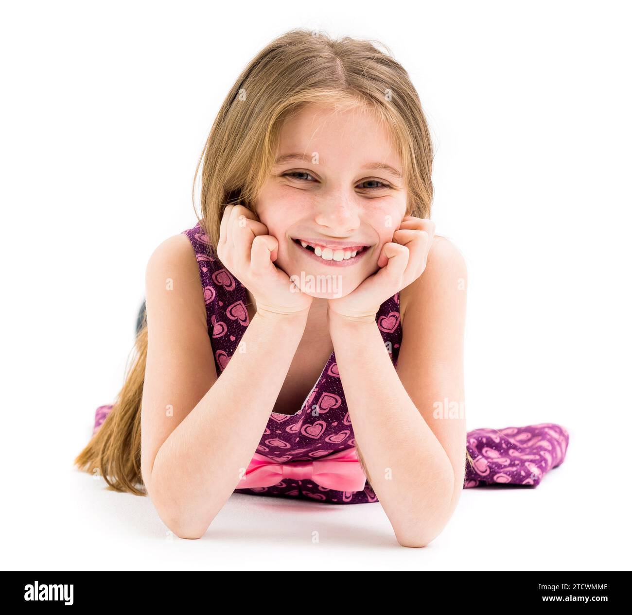 Lovely teenage girl lying on the floor, smiling and holding her head