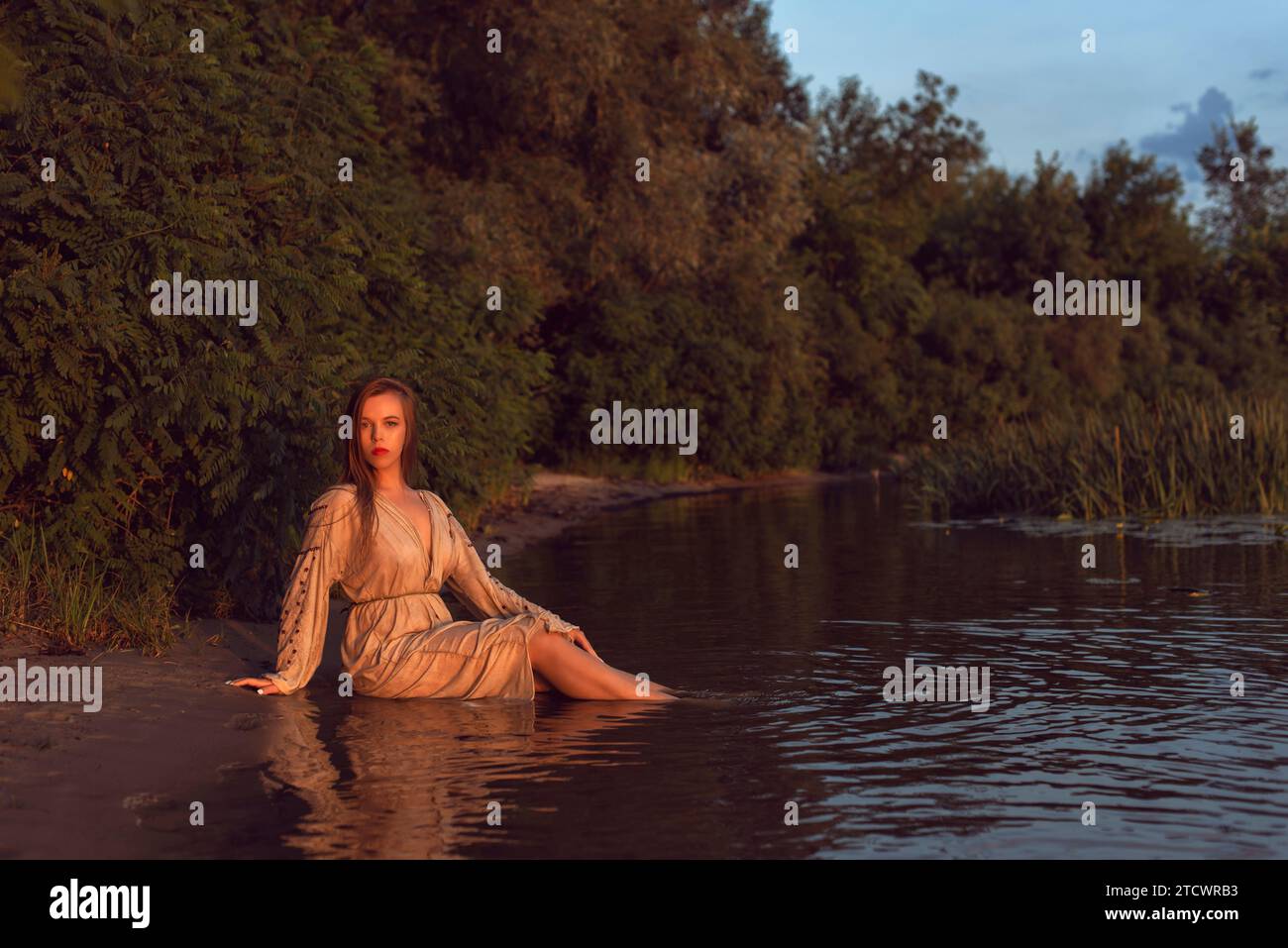 Girl in an embroidered dress on the lake Stock Photo - Alamy