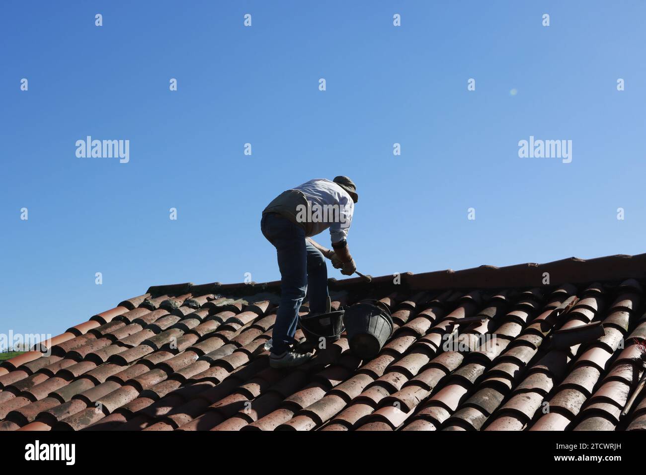 Trabajador retejando un tejado viejo Stock Photo