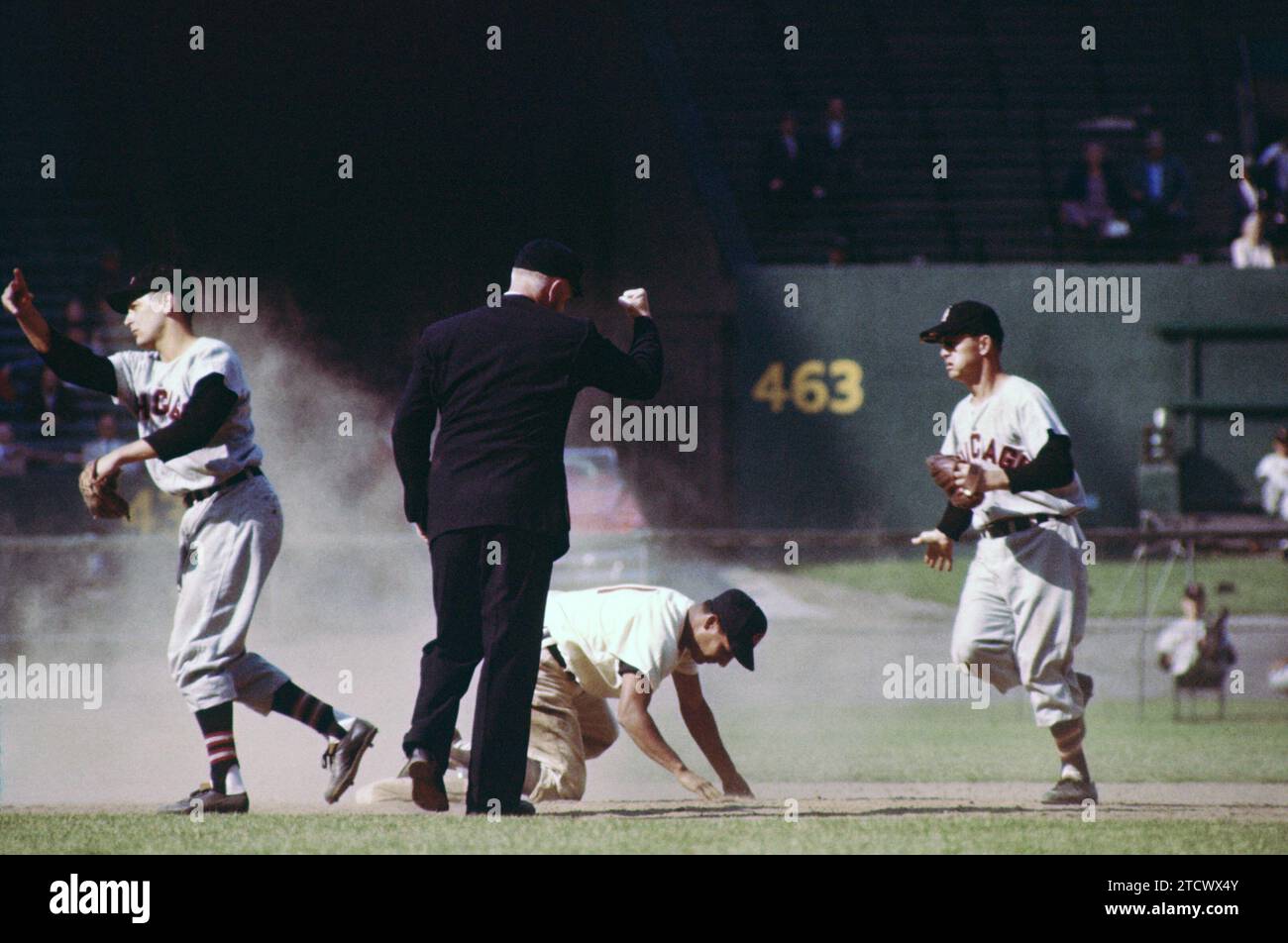 CLEVELAND, OH - MAY 26:  Bobby Avila #1 of the Cleveland Indians is caught stealing as shortstop Jim Brideweser #3 of the Chicago White Sox throws the ball around the diamond as umpire Red Flaherty makes the out sign on May 26, 1955 at Cleveland Municipal Stadium in Cleveland, Ohio.  (Photo by Hy Peskin) *** Local Caption *** Bobby Avila;Jim Brideweser;Red Flaherty Stock Photo