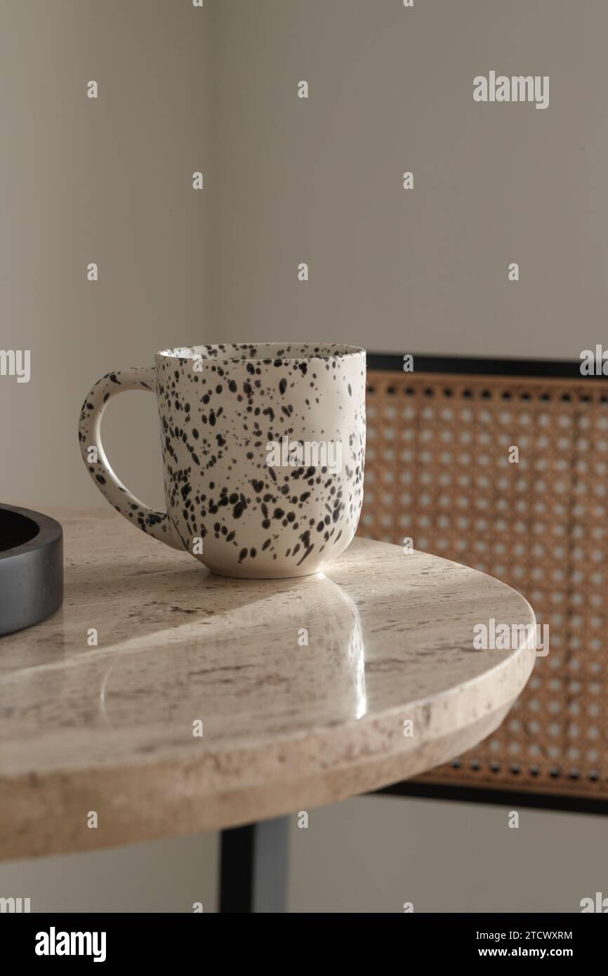 Black and white ceramic cup on travertine coffee table. Wabi-sabi interior details for decoration Stock Photo