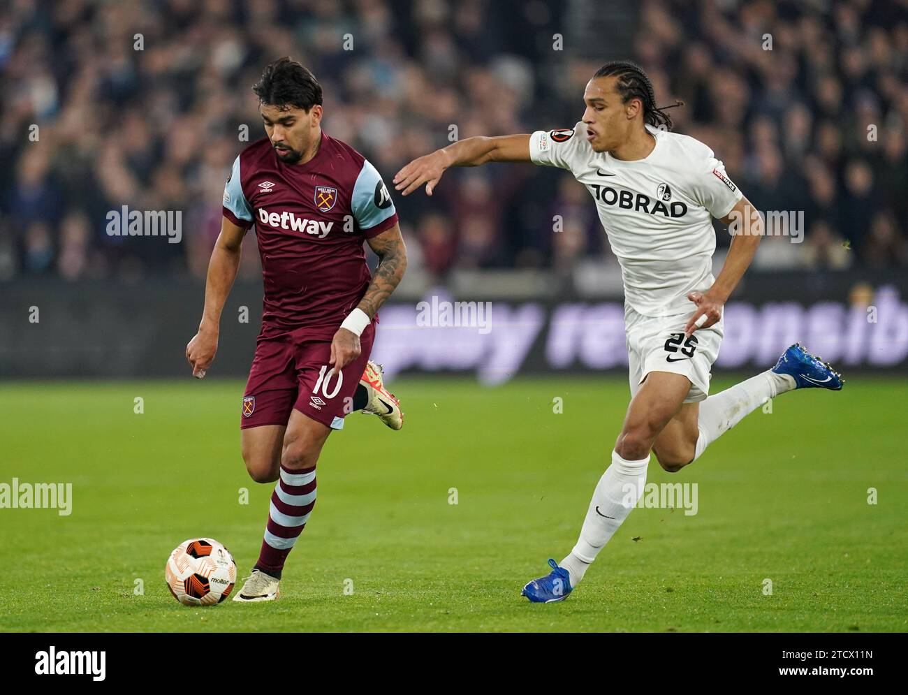 West Ham United's Lucas Paqueta (left) and Freiburg's Kiliann Sildillia battle for the ball during the UEFA Europa League group A match at London Stadium, London. Picture date: Thursday December 14, 2023. Stock Photo