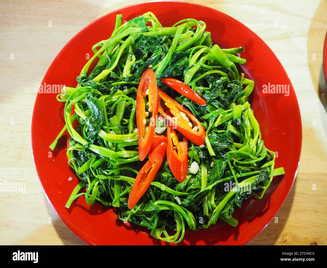 Coocked morning glory dish. Morning glory is also know as water spinach, water convolvulus, ong-choy, kang-kung or swamp cabbage. Stock Photo