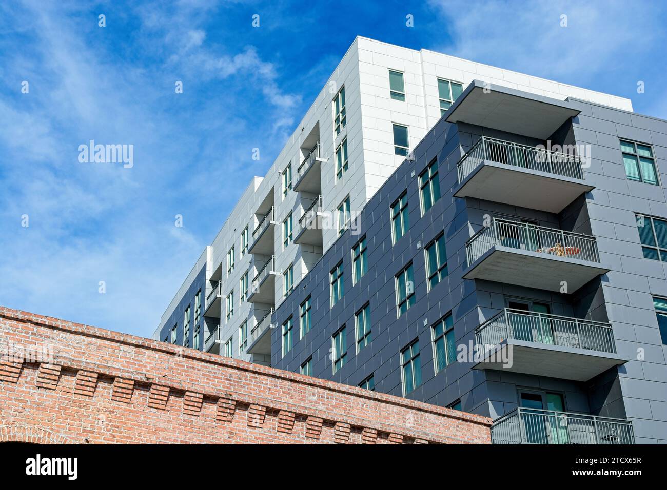 Contemporary mid-rise apartment building behind weathered brick ...
