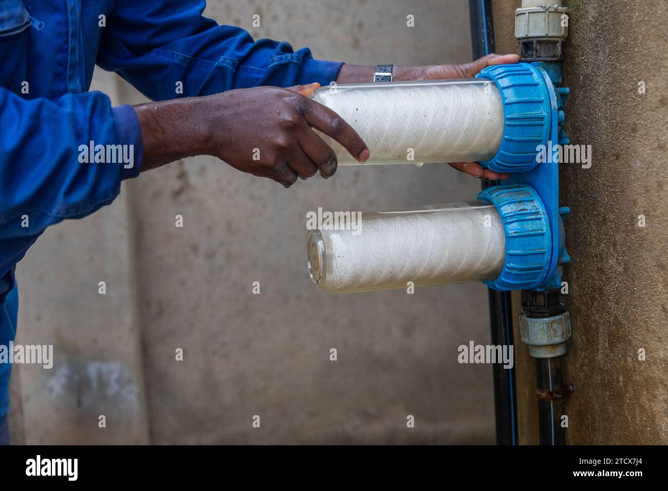 African plumber replaces the water filters. Clean water concept. Stock Photo