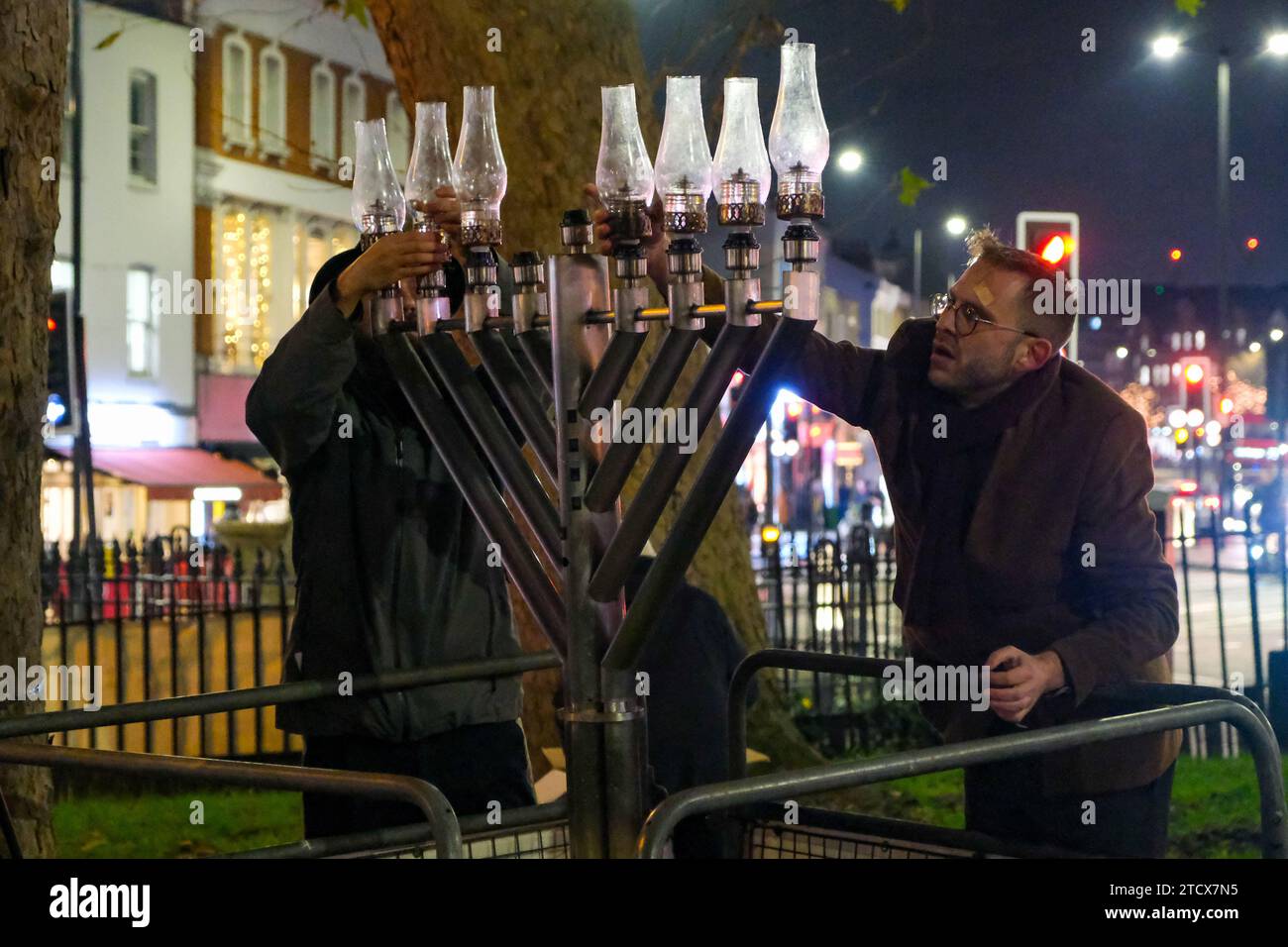 London, UK. 14th December, 2023. A memorah is reinstalled in Islington Green. A solidarity event attended by MPs, community leaders and members of the public was held after the menorah was vandalised earlier today. Rabbi Mendy Korer led the proceedings, relighting the candles  - and the eighth and final one for the Hanukkah festival. The Metropolitan Police investigating, believe that the menorah was intentionally damaged, as antisemitic incidents increase since the Israel-Hamas war was declared. Credit: Eleventh Hour Photography/Alamy Live News Stock Photo