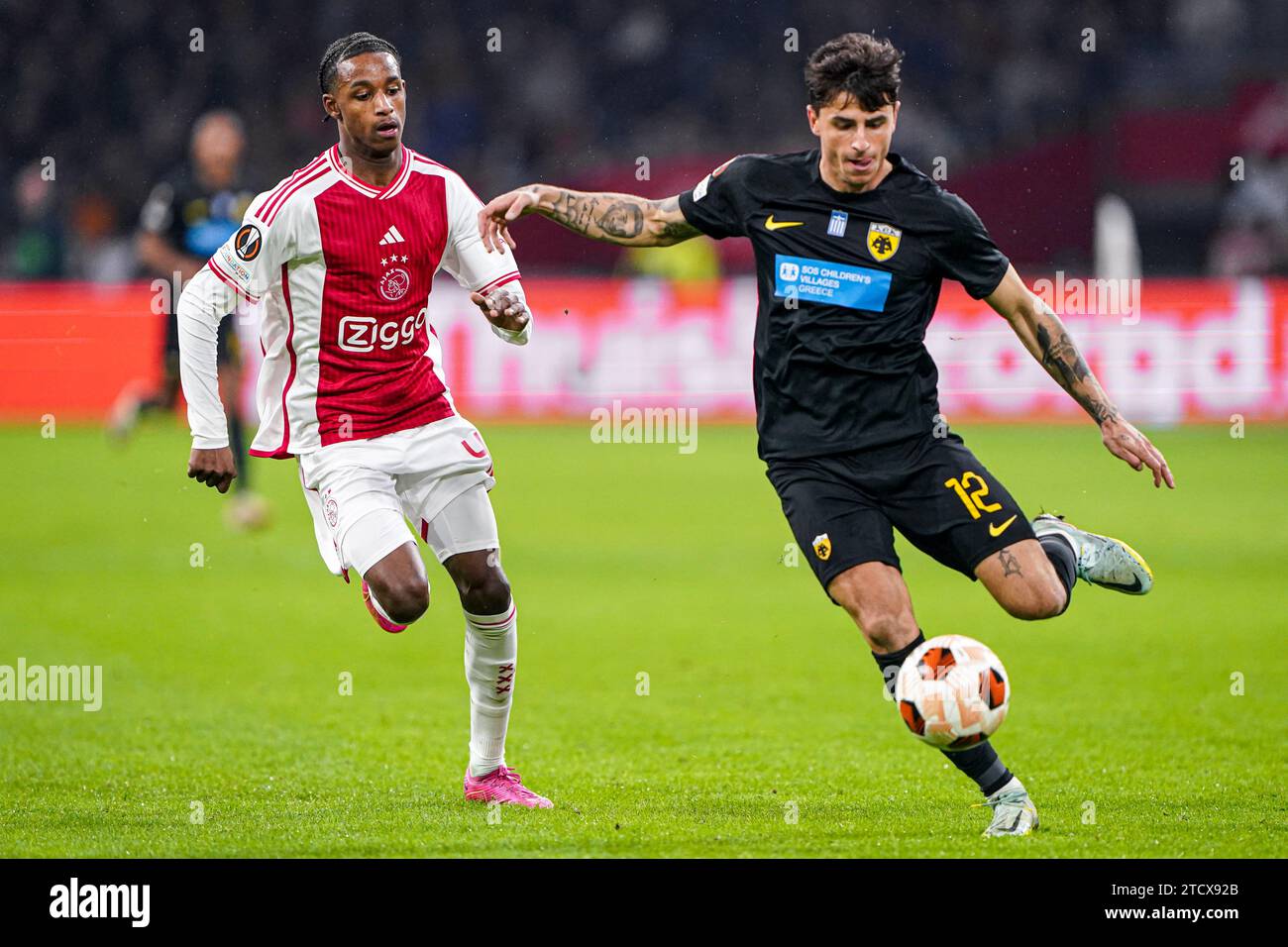Amsterdam, Netherlands. 14th Dec, 2023. AMSTERDAM, NETHERLANDS - DECEMBER 14: Arjany Martha of Ajax, Lazaros Rota of AEK Athens battle for the ball during the UEFA Europa League 2023/24 Group B match between Ajax and AEK Athens at Johan Cruijff ArenA on December 14, 2023 in Amsterdam, Netherlands. (Photo by Andre Weening/Orange Pictures) Credit: Orange Pics BV/Alamy Live News Stock Photo