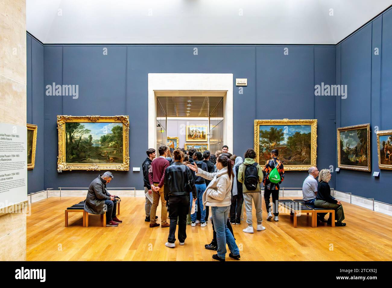 A group of young students being given a tour of the artworks within the  Richelieu wing of The Louvre Museum in Paris ,France Stock Photo
