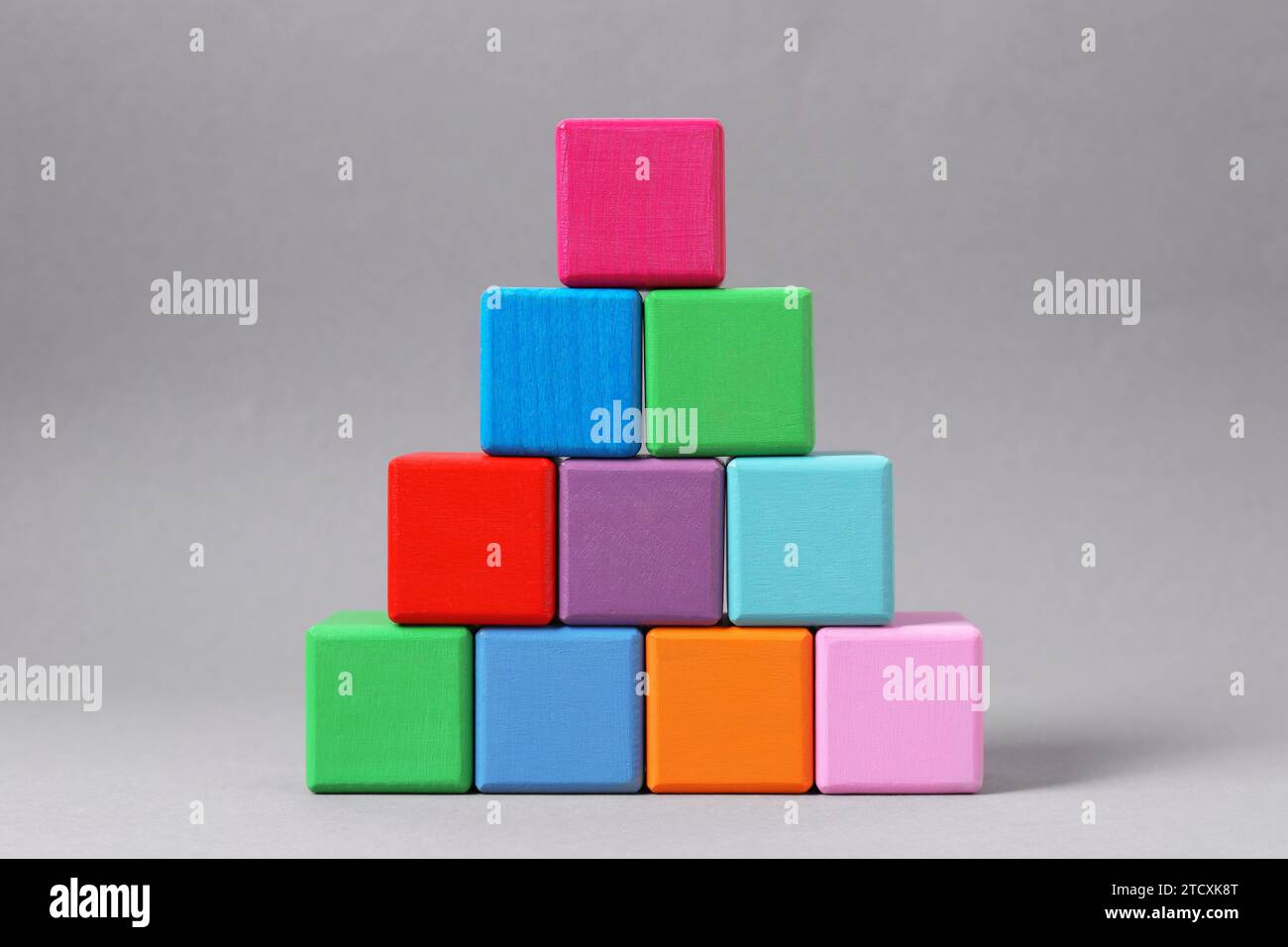 Pyramid of blank colorful wooden cubes on light grey background Stock Photo