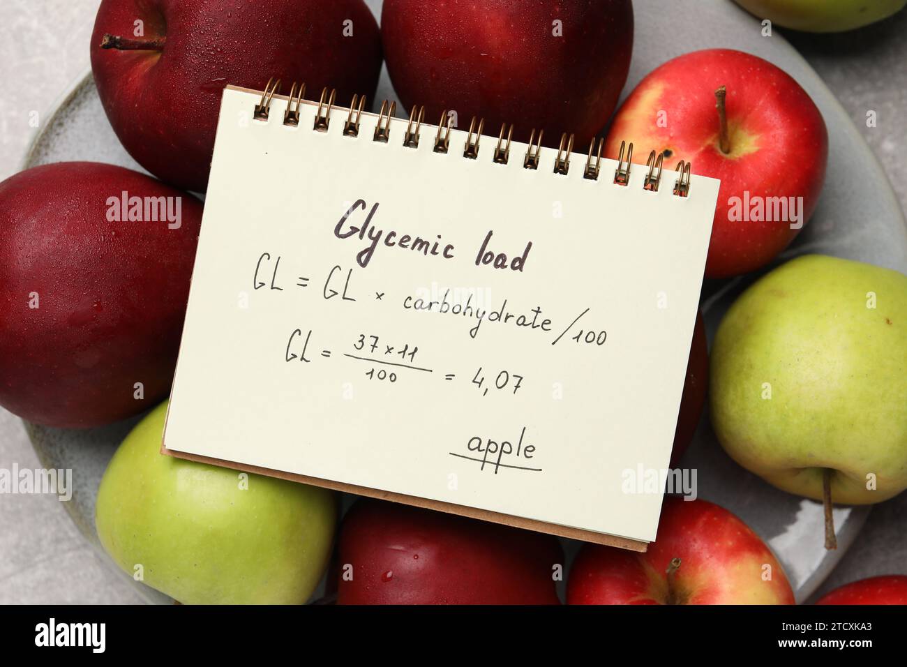 Notebook with calculated glycemic load for apples and fresh fruits on table, top view Stock Photo