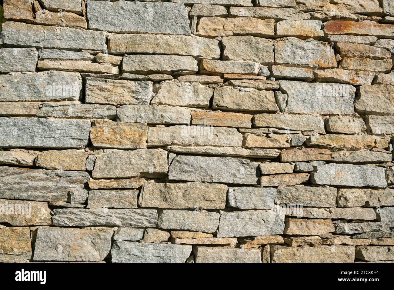 texture of a stone wall with rugged and wrinkled surface, characterized by a variety of earthy tones and intriguing details. log cabin, house. Stock Photo