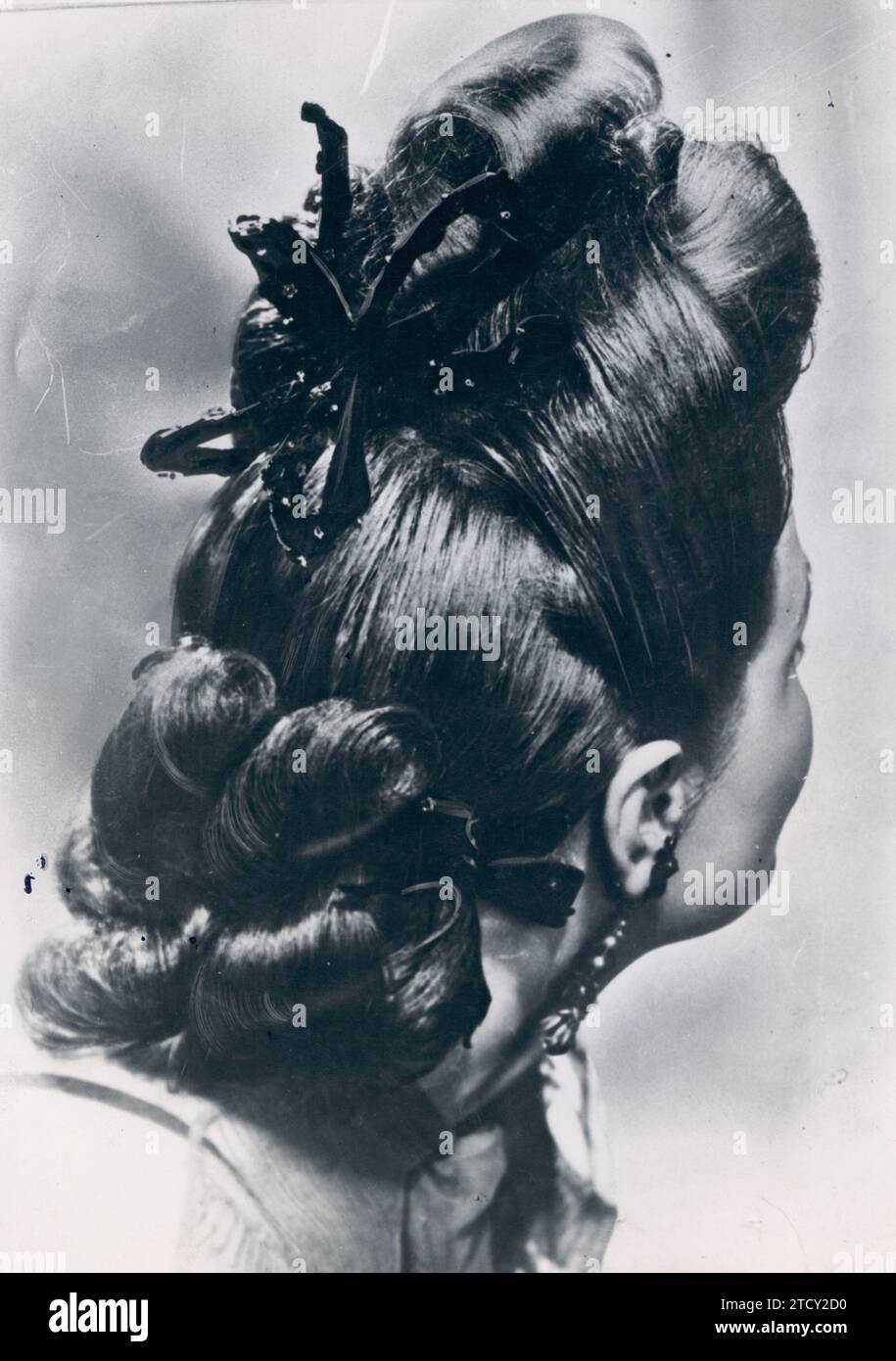 12/31/1945. In the Image, original fantasy hairstyle composed of Large Curls on the forehead and very tight hair on the Sides. The neck from behind is covered with a group of curls held by a velvet ribbon, which matches the one at the nape of the neck. Credit: Album / Archivo ABC Stock Photo