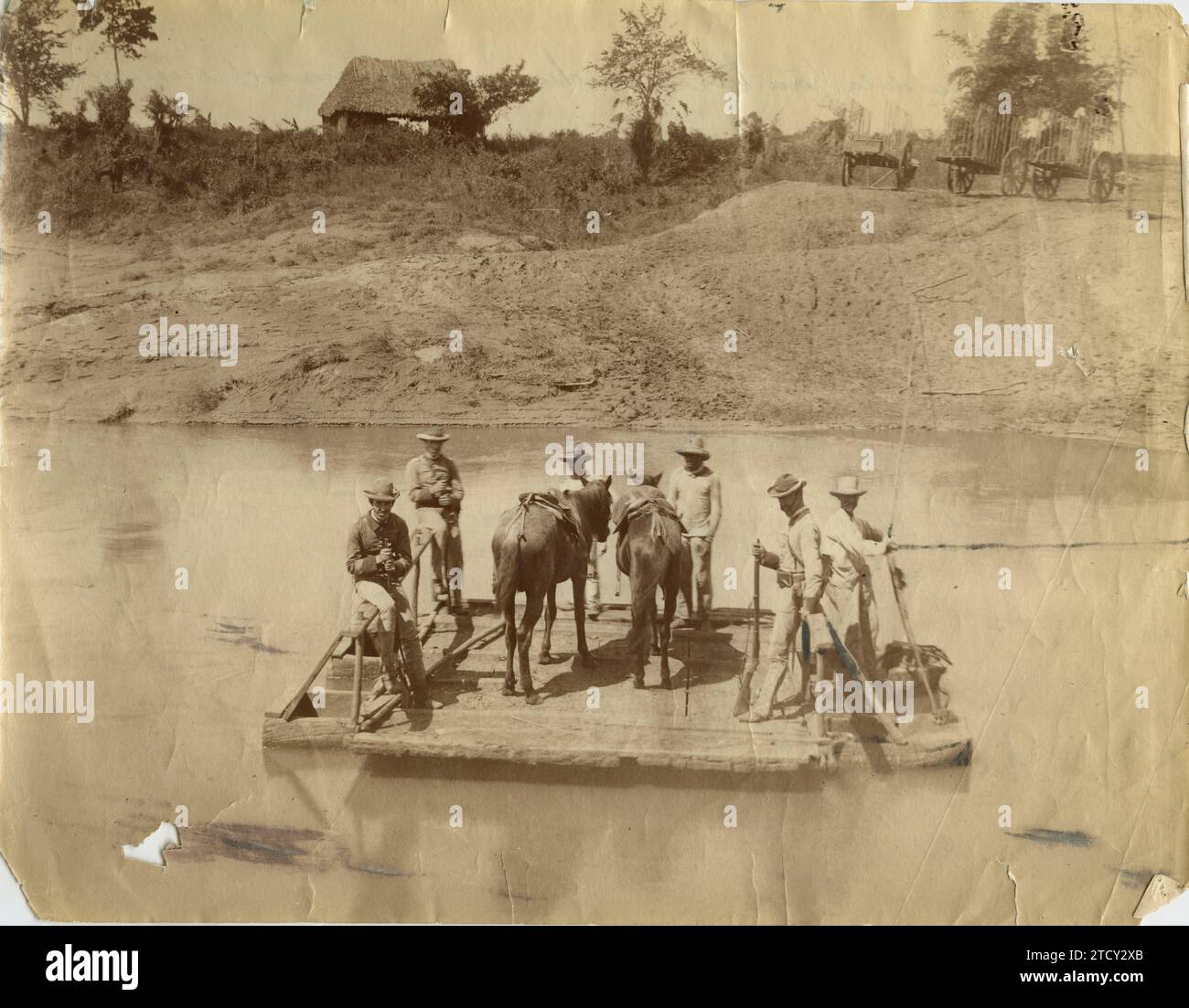 Cuba, January 1895. Cuban War. A couple from the Civil Guard takes prisoners taken by one of the columns that operate in the Eastern Department to Santiago de Cuba. The group is crossing the Cauto River on a tow raft. Credit: Album / Archivo ABC / Gómez Carrera Stock Photo