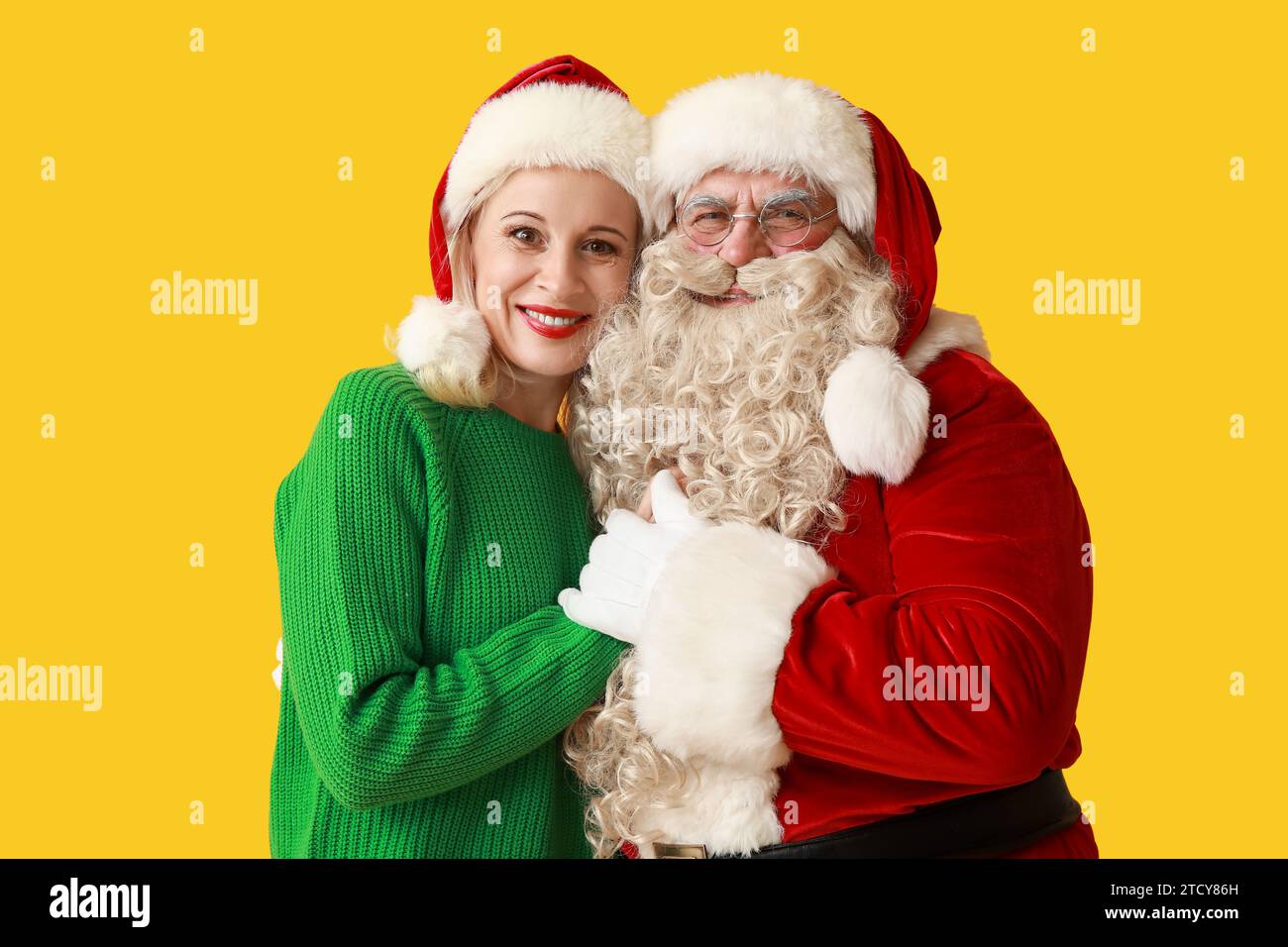 Happy Santa Claus and beautiful mature woman in Christmas hats on ...