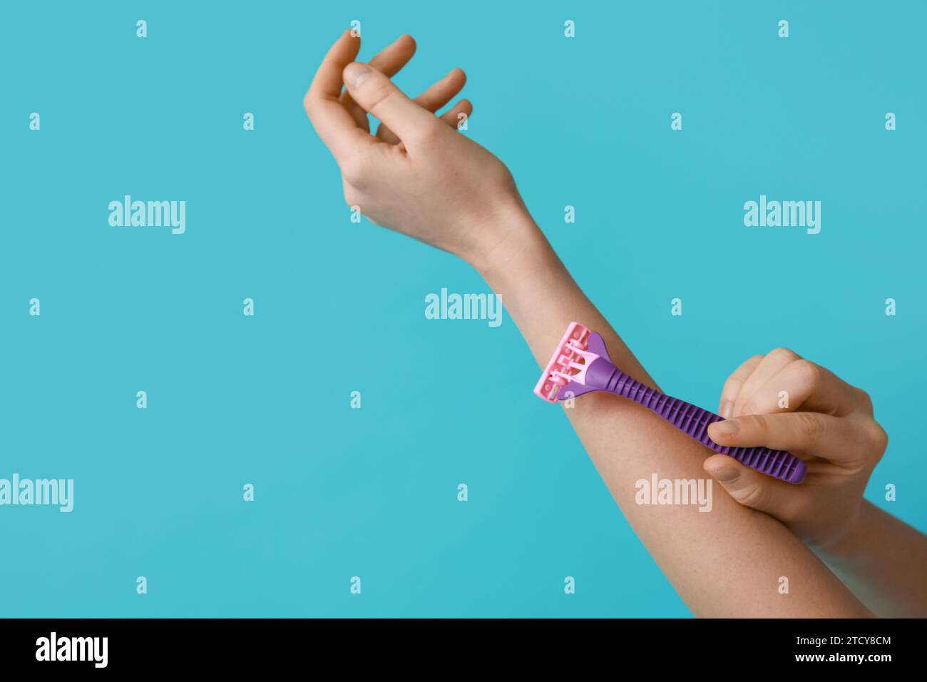 Female hands with razor on turquoise background Stock Photo - Alamy