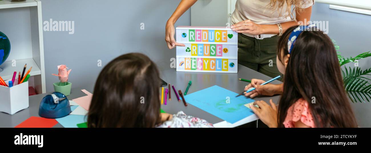 Teacher explaining to students a ecologic process using lightbox with ...