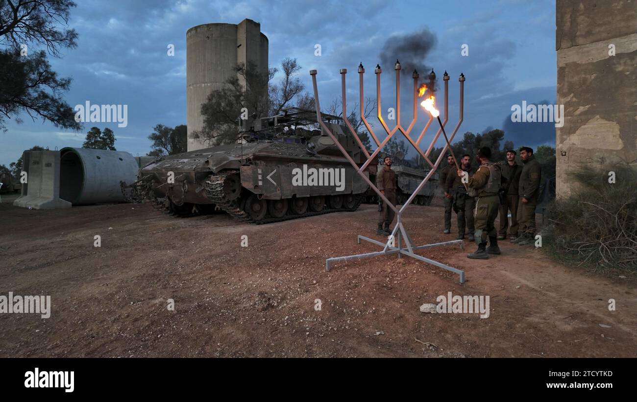 Israeli soldiers light the sixth candle of the sixth day of the Jewish Hanukkah holiday at a position near the Gaza border amid continuing battles between Israel and the militant group Hamas on December 12, 2023 in Gaza border, Israel. It has been more than two months since the Oct. 7 attacks by Hamas that prompted Israel's retaliatory air and ground campaign in the Gaza Strip. Stock Photo