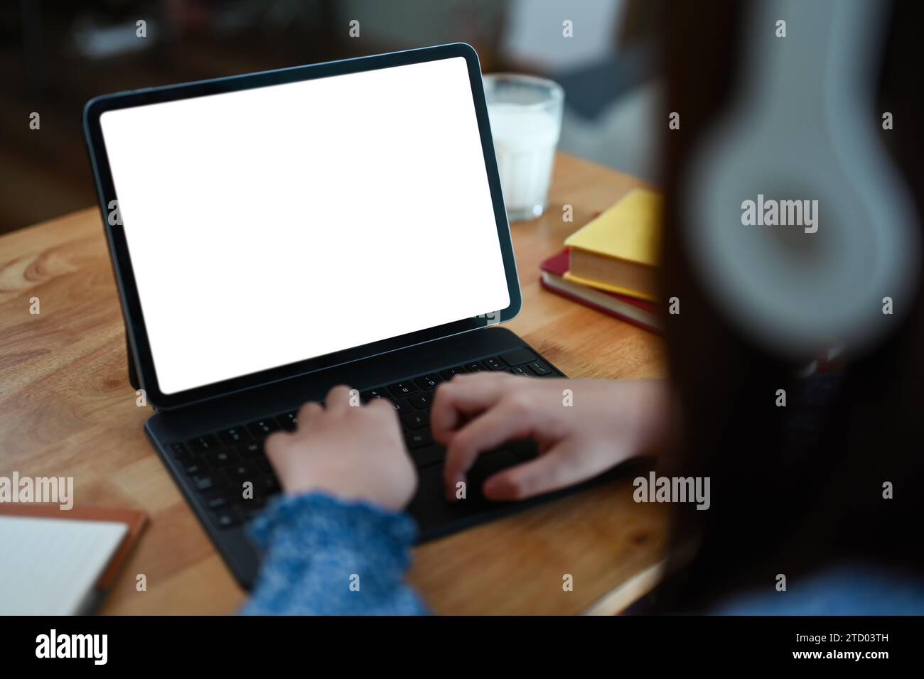 Closeup child girl hands typing on keyboard of digital tablet while ...