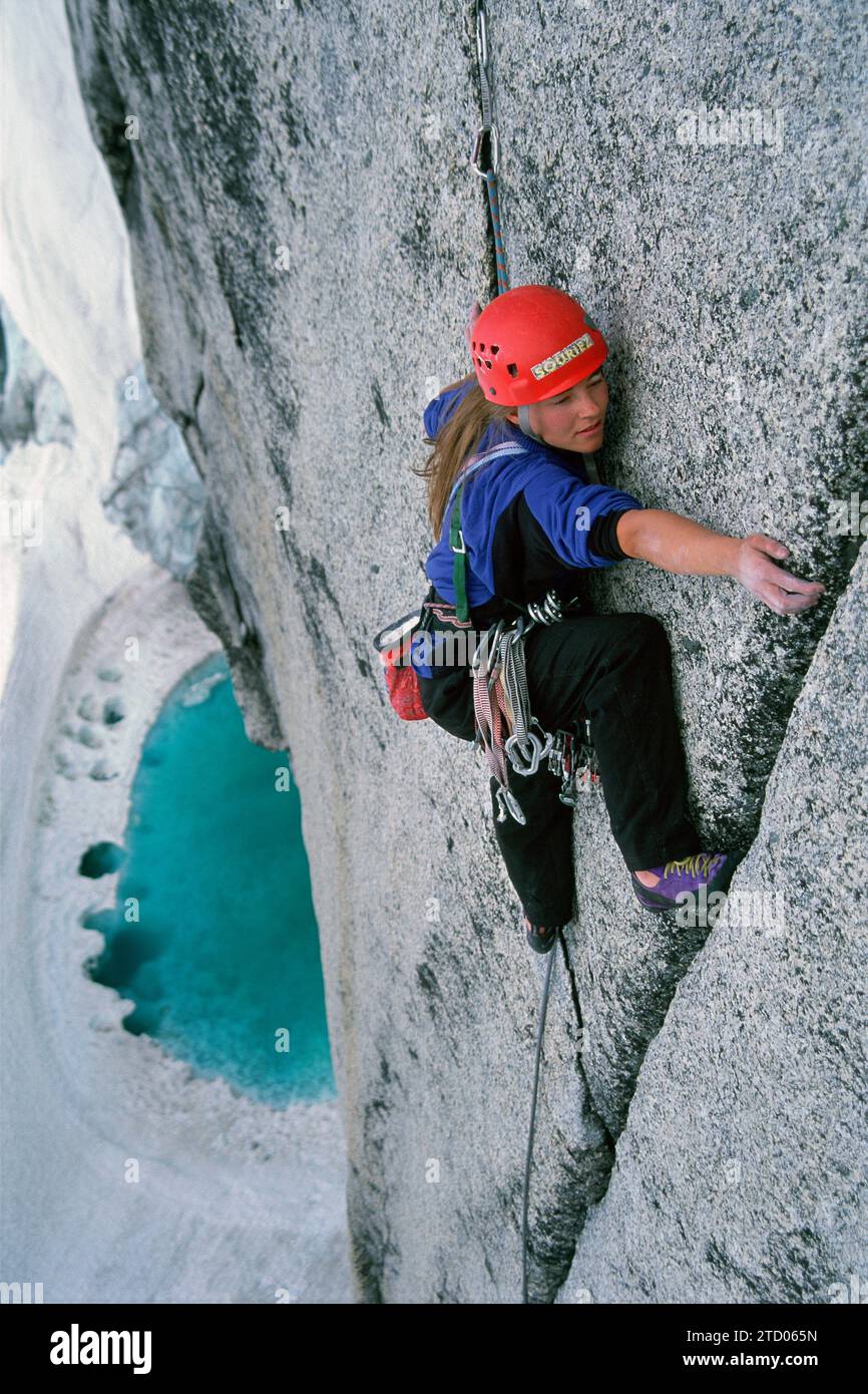 A girl climbs above a glacial tarn. Stock Photo