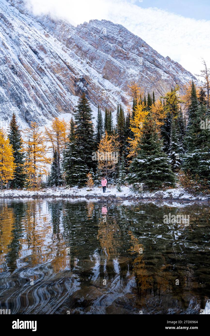 Lone Hiker Standing Over Reflection In Beautiful Mountain Landscape Stock Photo