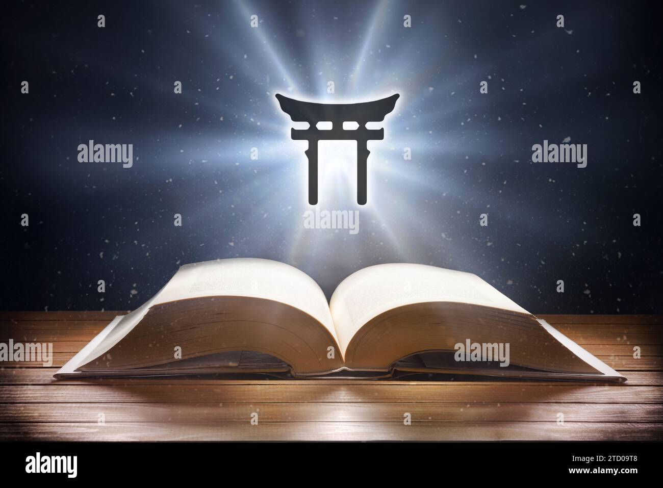 Open book on wooden table and shintoism symbol with beam of light with dark background. Front view. Stock Photo