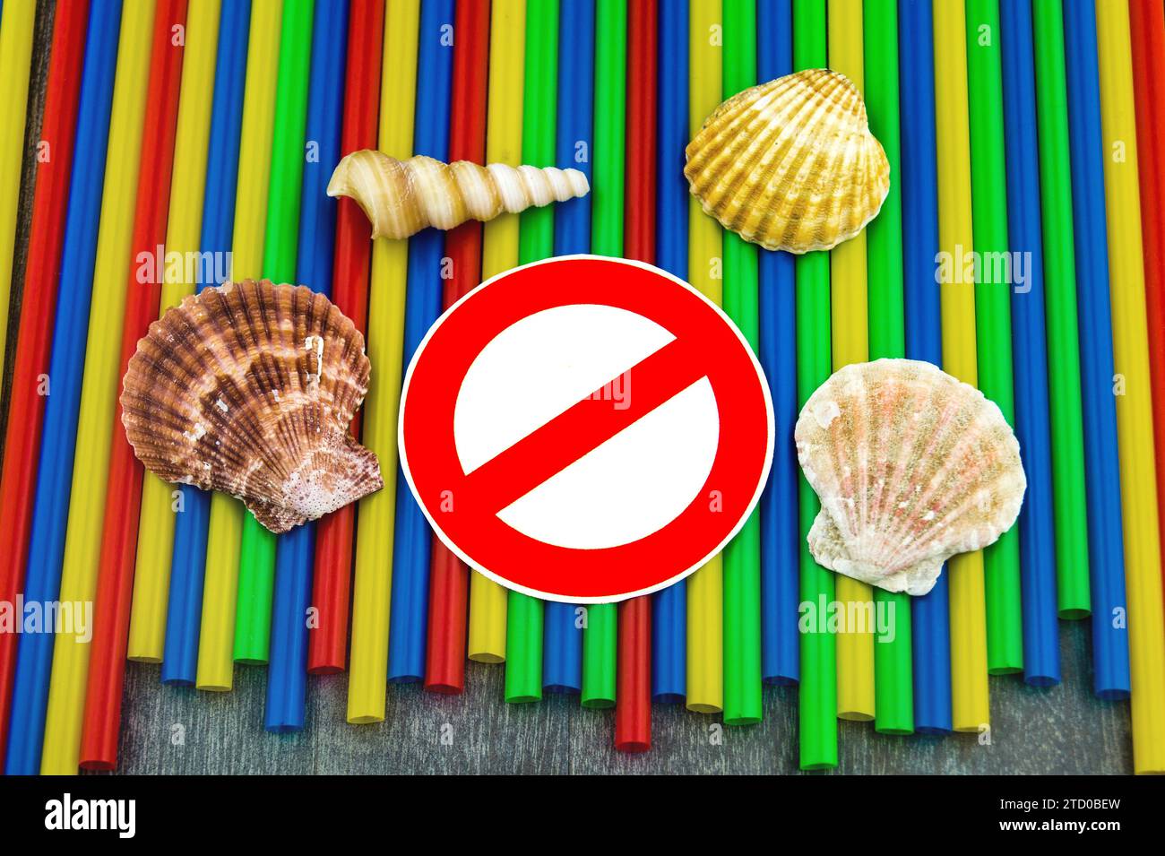Plastic straws with prohibition sign, shells and snail shells from the