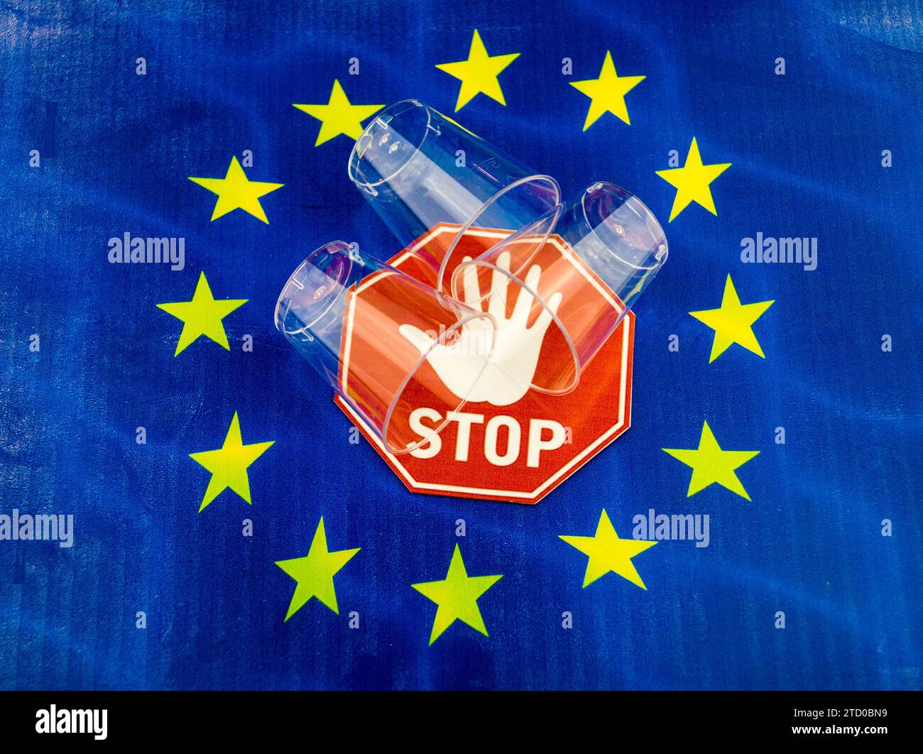 Plastic cups on European flag with stop sign, ban on plastic in the EU