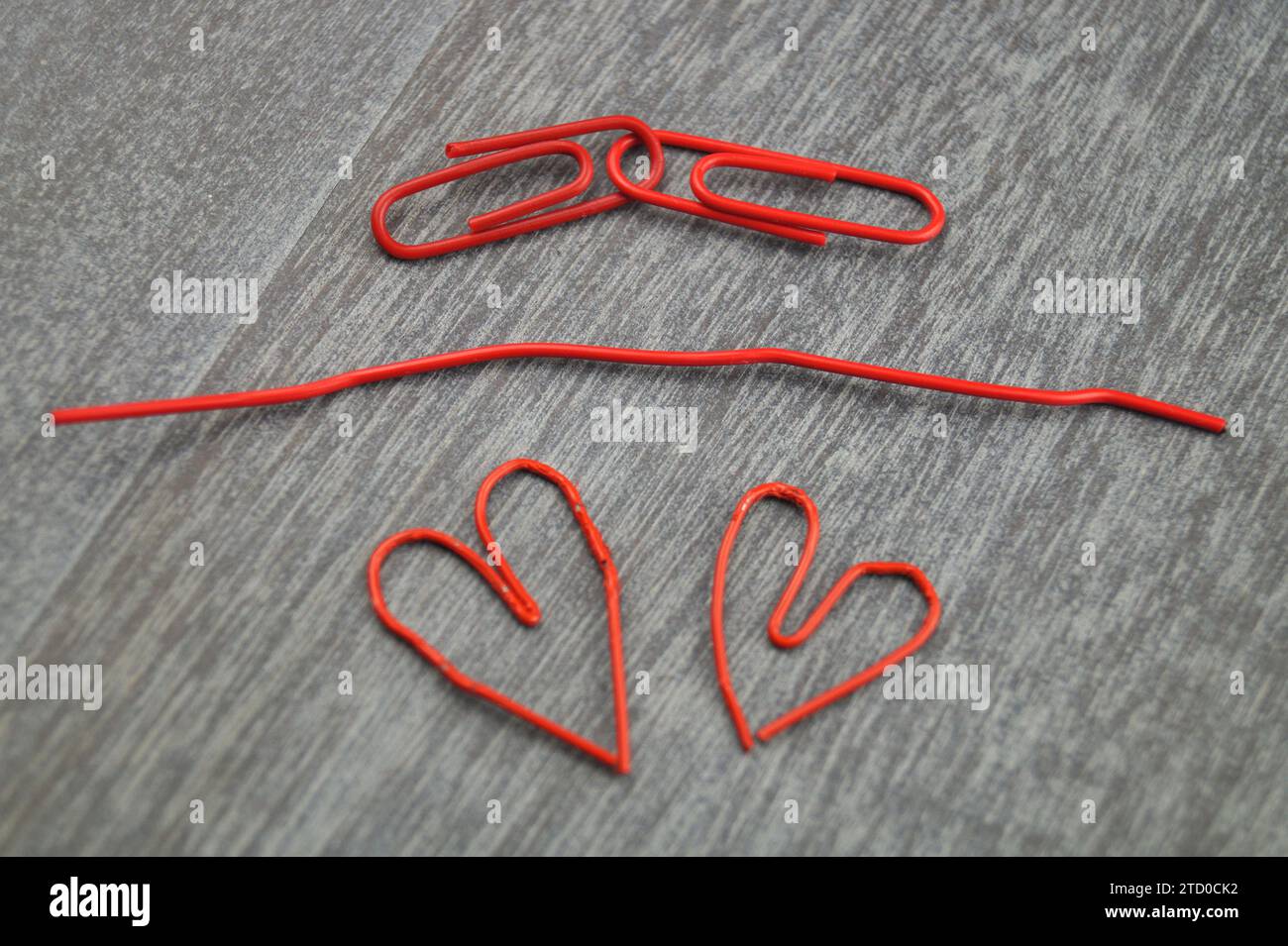 red paper-clips, two of them heart-shaped, love in the office Stock Photo