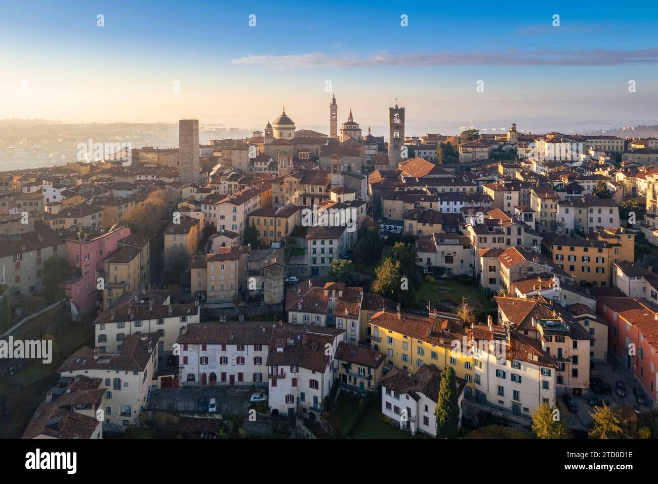 View of the rooftops, churches and towers of the Upper Town (Città Alta) of Bergamo city at sunrise. Bergamo, Lombardy, Italy. Stock Photo