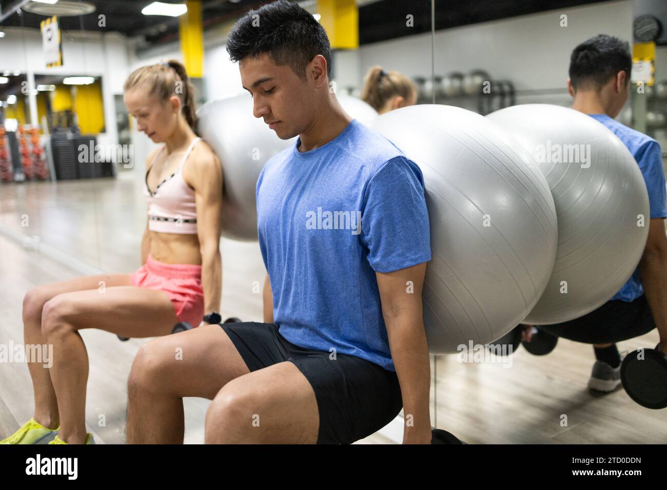 Two focused fitness enthusiasts engage in strength training exercises