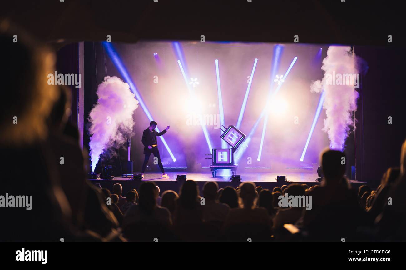 Professional male magician showing magic trick with glass boxes on