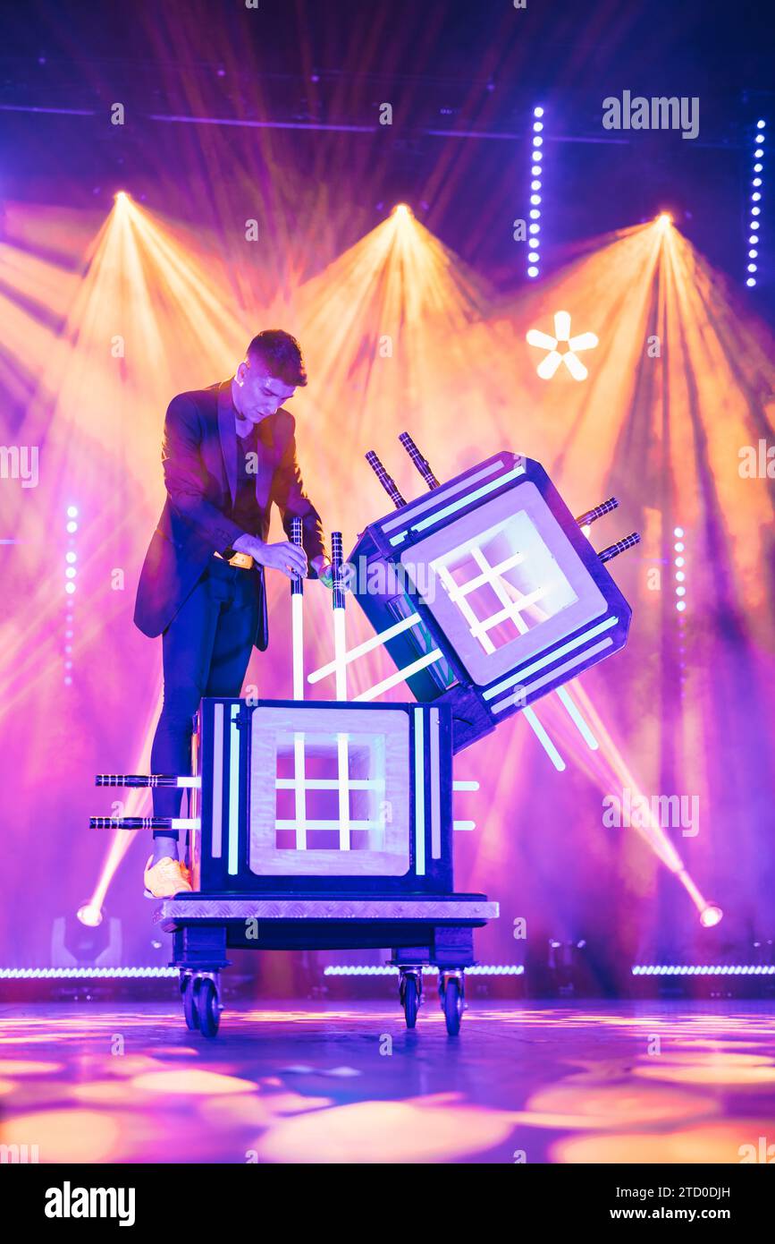 Professional male magician on top of a table showing magic trick with