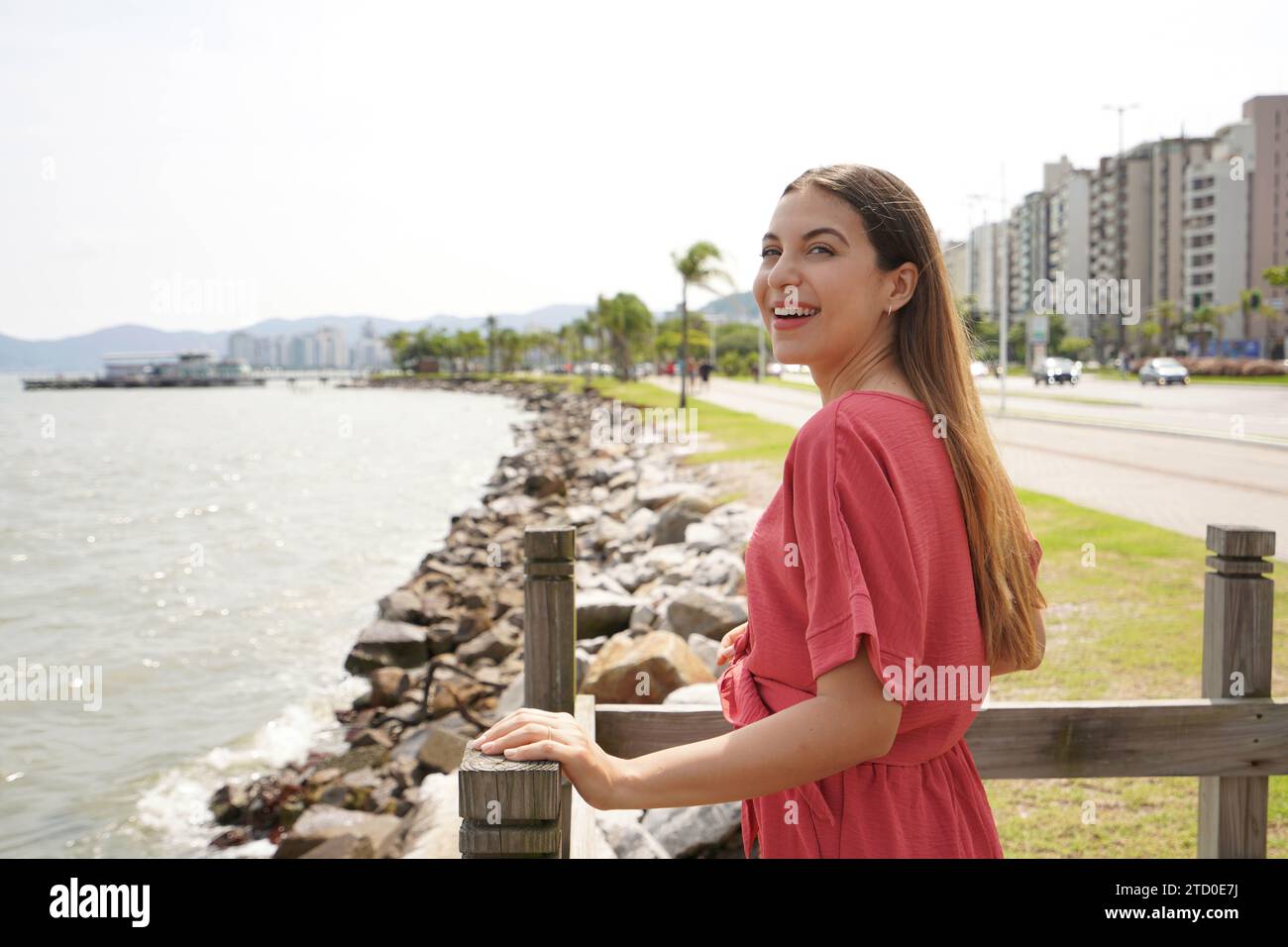 Portrait of smiling fashion woman enjoying relaxed on seafront of Florianopolis, Brazil Stock Photo