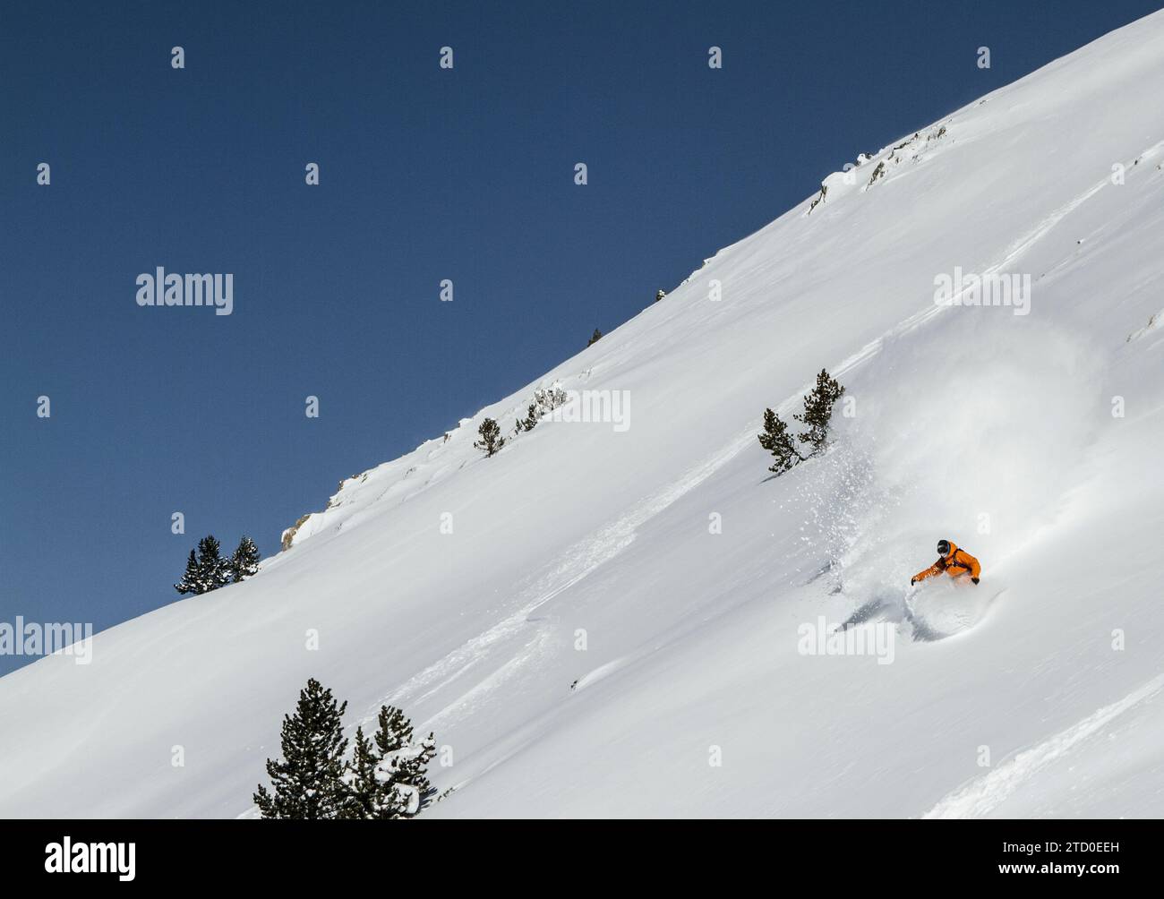 Unrecognizable active hiker dressed in sportswear practicing snowboard mountain against cloudy sky during winter vacation on sunny day Stock Photo