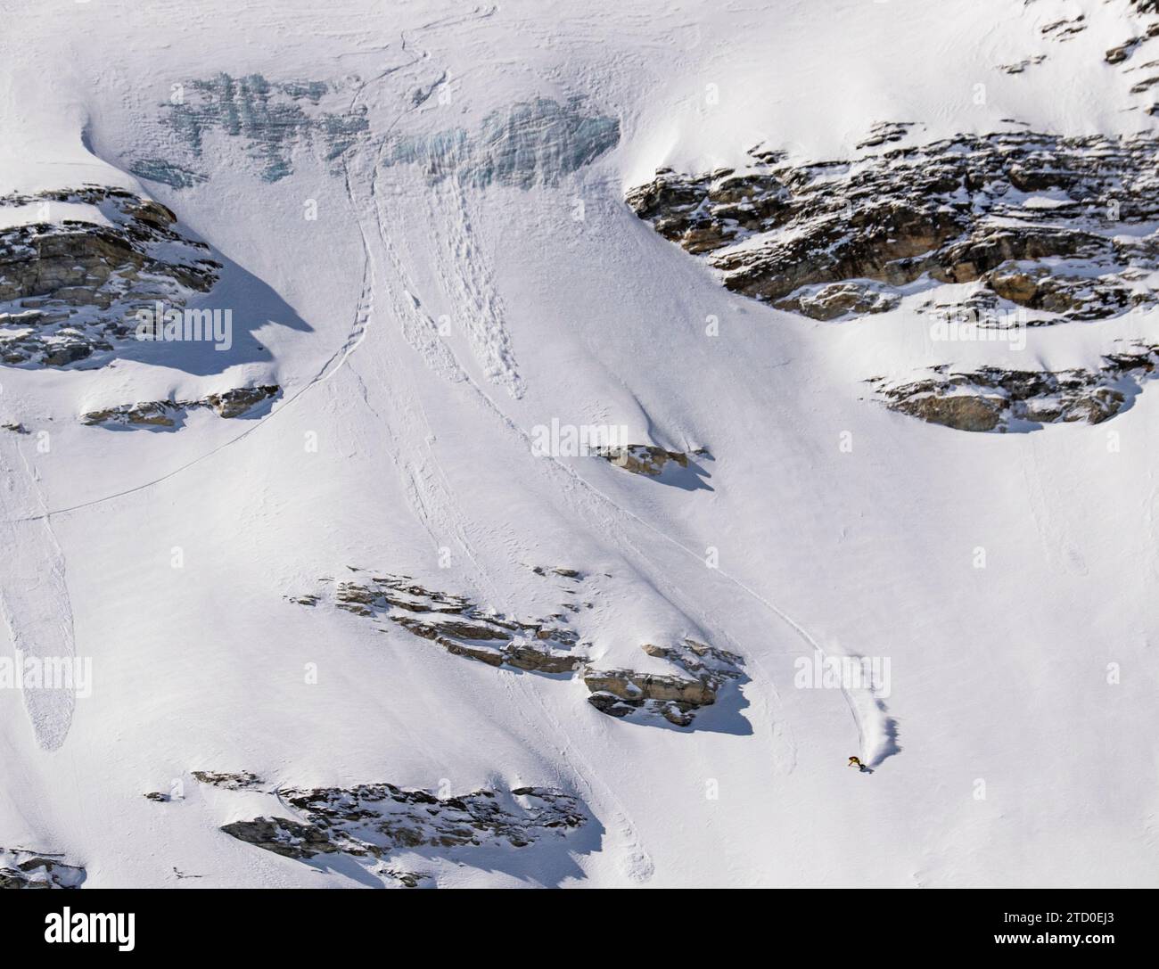 Aerial view of anonymous tourist snowboarding on majestic snow covered