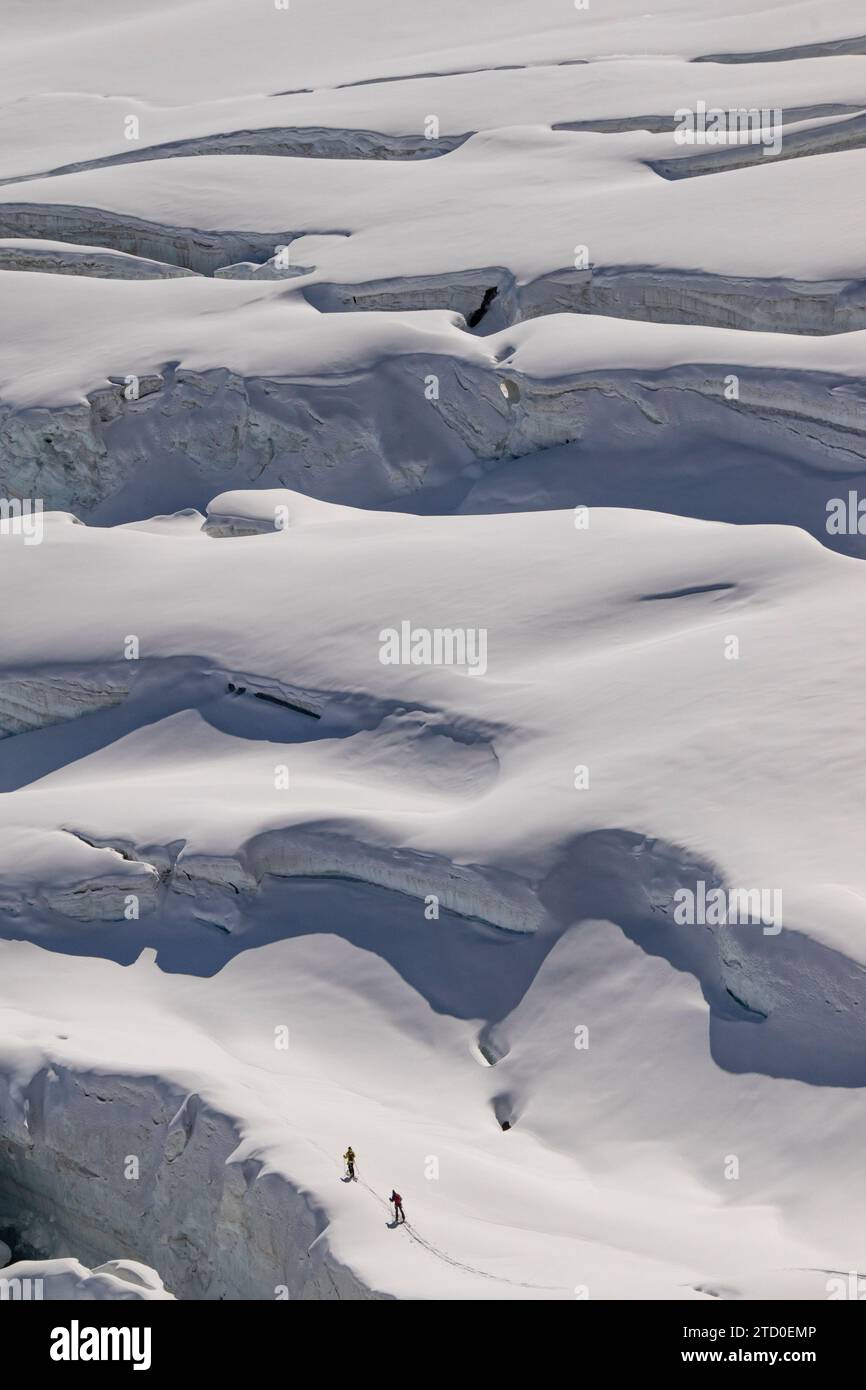 Aerial view of anonymous skiers in warm clothes making their way across the pristine, snow