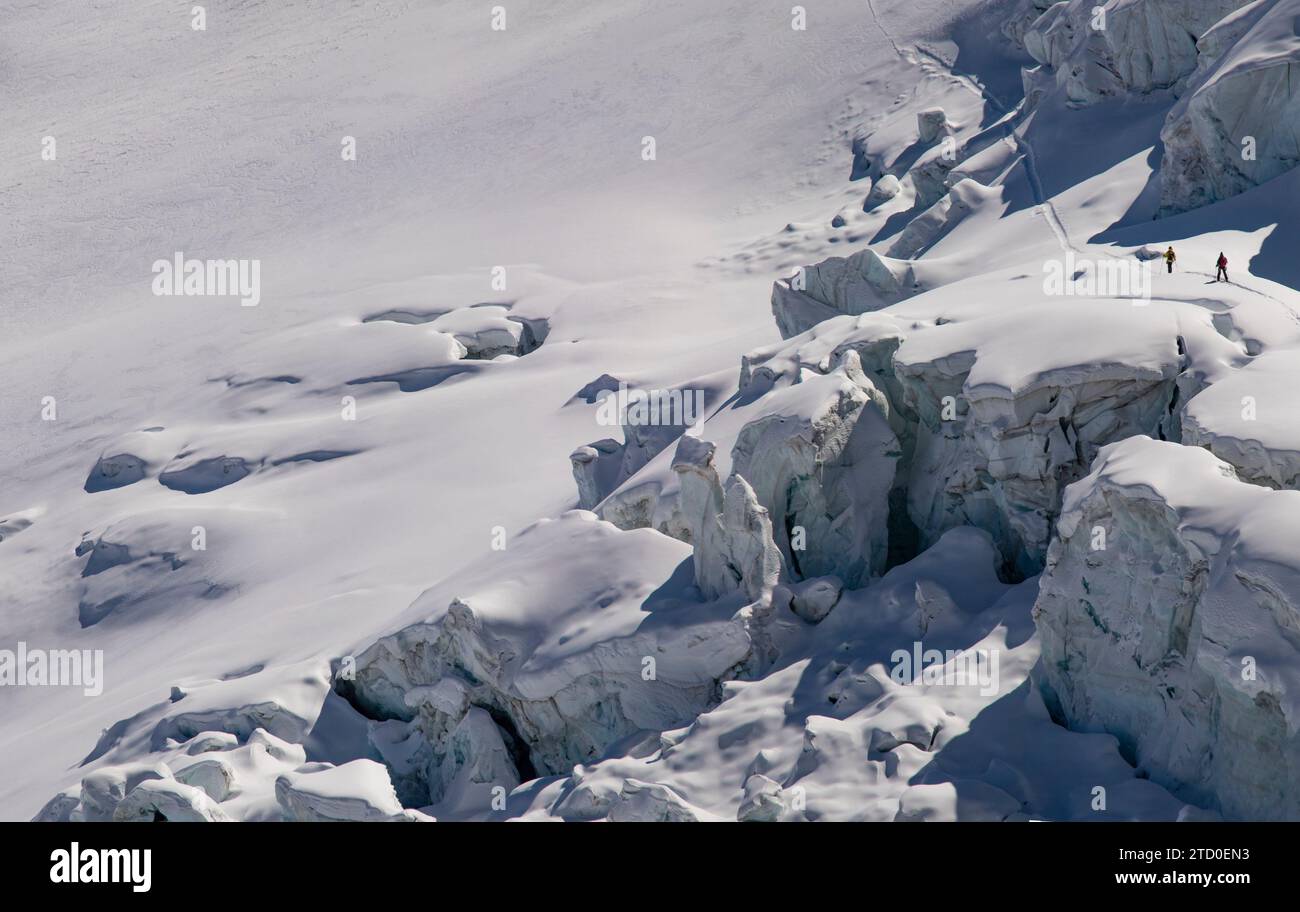 Aerial view of anonymous skiers in warm clothes making their way across the pristine, snow