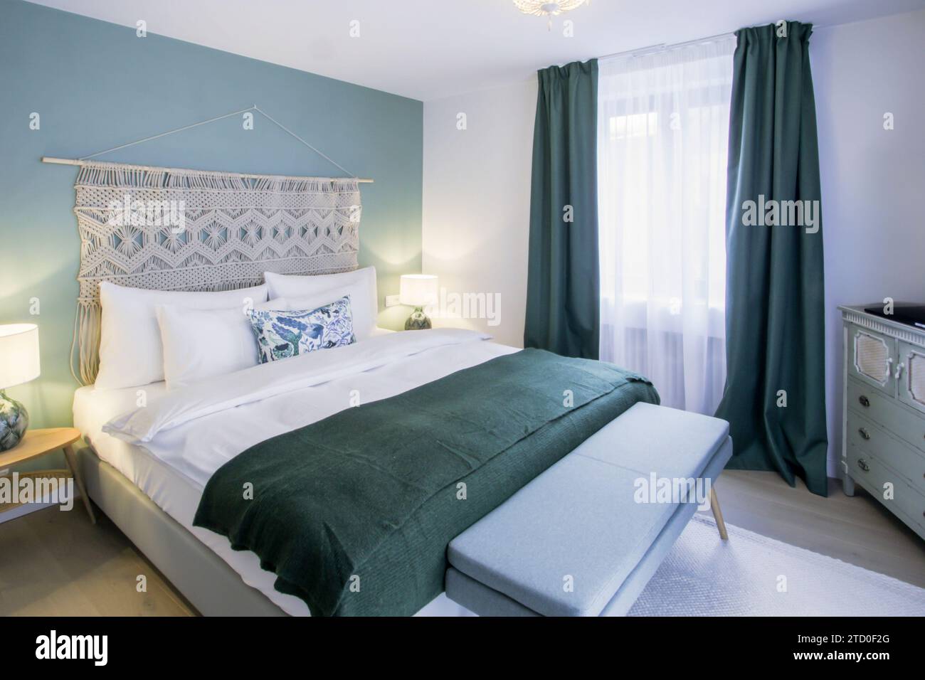 a-cozy-and-stylish-bedroom-featuring-a-white-bed-with-dark-green