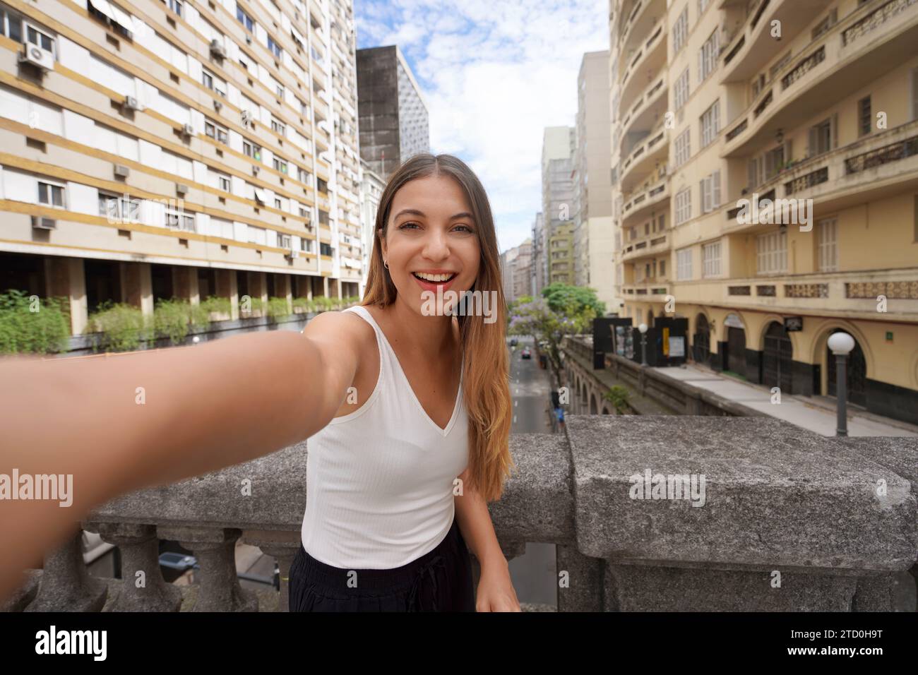 Beautiful smiling girl takes self portrait on Otavio Rocha Viaduct landmark in the city of Porto Alegre, Rio Grande do Sul, Brazil Stock Photo