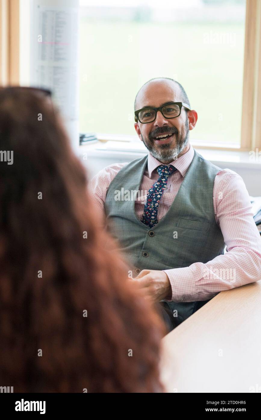 A Level students talk to an adult mentor at their college who is counselling them. Stock Photo