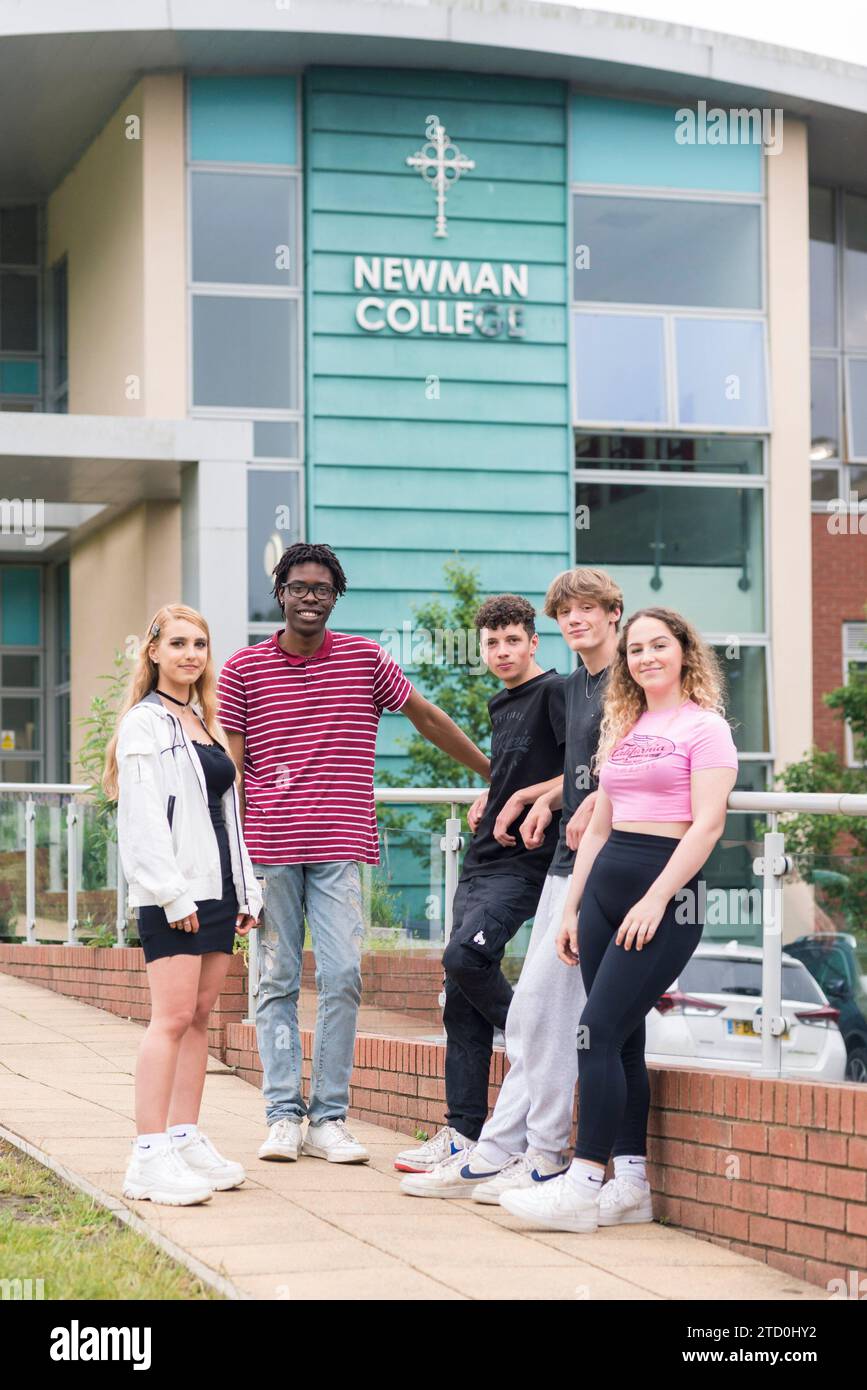 Pupils of Newman College in Brighton and Hove stand outside with the college sign in the background. Stock Photo