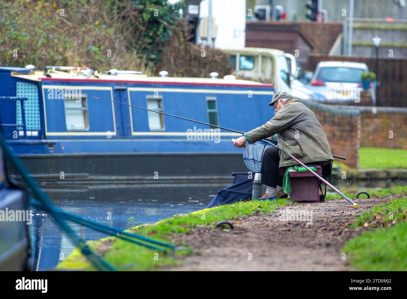 Stourbridge, UK. 15th December, 2023. UK weather: it's a cool and dull morning in the Midlands but it doesn't stop people getting out and enjoying their favourite pastime. This gentleman nets a fish, caught on the canal, during a quiet morning of fishing, away from the hustle and bustle of Christmas town shopping. Credit: Lee Hudson/Alamy Live News Stock Photo