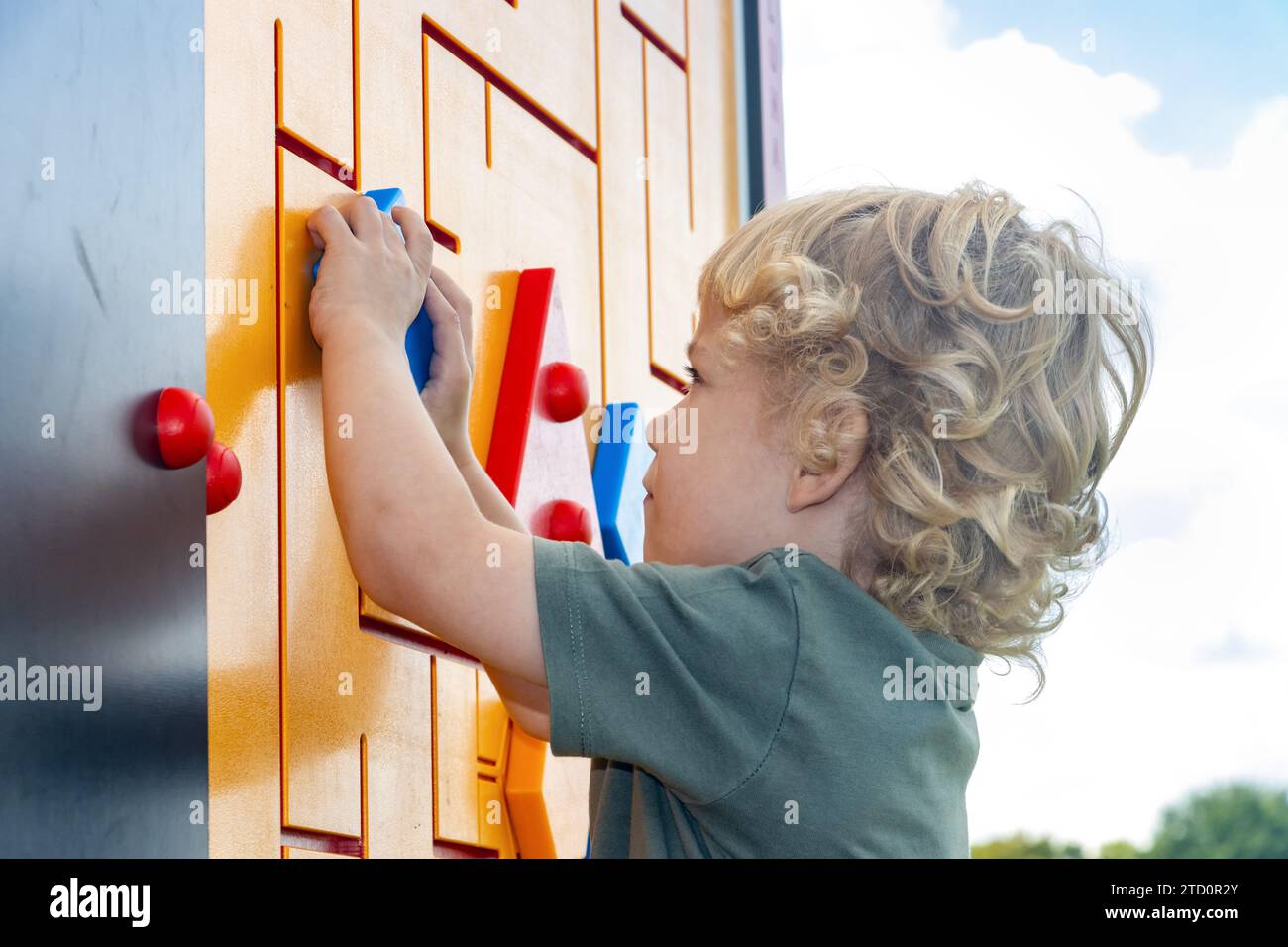 Little boy explores outdoor rebus on playground Stock Photo